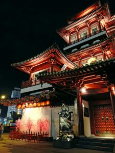 Illuminated Buddha Tooth Relic Temple in Chinatown, Singapore at night showcasing traditional architecture.
