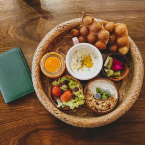 Overhead shot of a colorful breakfast assortment in a wicker basket, perfect for food photography.